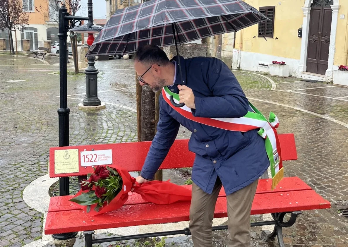 25 novembre, a Nereto un mazzo di fiori su  una panchina rossa e luoghi simbolo illuminati di arancione